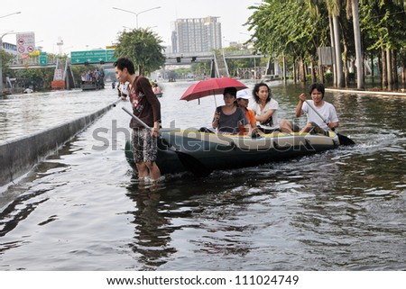 BANGKOK - NOV 4: A boat navigates a flooded road in Pinklao district in rescuing flood victims as Thailand faces its worst flooding in 50 years on Nov 4, 2011 in Bangkok, Thailand.