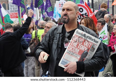 LONDON - MARCH 26: An unidentified man sells copies of Socialist Worker during a large austerity rally on March 26, 2011 in London, UK. An estimated 250,000 people joined the TUC organised protest.