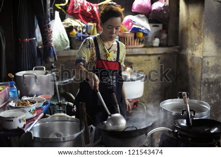 BANGKOK - AUG 23: An unidentified street vendor cooks at a night market on Aug 23, 2012 in Bangkok, Thailand. According gov stats there are over 16,000 registered street vendors in Bangkok.