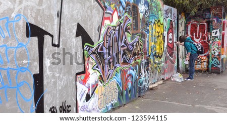 BRISTOL - SEPTEMBER 26: A street artist sprays a graffiti piece in the Stokes Croft area of the city on September 26, 2010 in Bristol, UK. Bristol is internationally famed for its street art scene.