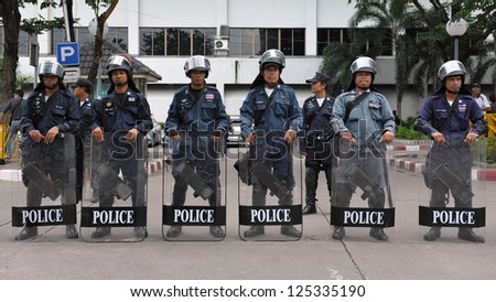 BANGKOK - AUG 9: Police stand guard outside the Criminal Court as red-shirts protest in opposition to the court meeting to revoke bail of key red-shirt leaders on Aug 9, 2012 in Bangkok, Thailand.