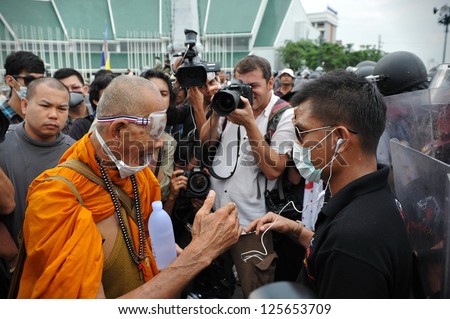 BANGKOK - NOV 24: A Buddhist monk talks with a Nationalist protester from Pitak Siam at a police roadblock on Makhawan Bridge during a large anti-government rally on Nov 24, 2012 in Bangkok, Thailand.