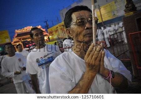 PHUKET - OCT 4: An unidentified man prays at a Taoist shrine during the Nine Emperor Gods Festival, known locally as the Phuket Vegetarian Festival, on Oct 4, 2011 in Phuket, Thailand.