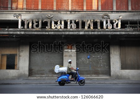 Bangkok - Jan 7: A Scooter Rider Passes A Derelict Building Of A Bankrupt Business On Jan 7, 2013 In Bangkok, Thailand. Many Buildings Remain Derelict Since The Asian Financial Crisis In 1997.