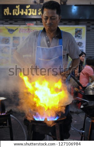 BANGKOK - DEC 13: A chef cooks food at a street-side restaurant in Chinatown on Dec 13, 2012 in Bangkok, Thailand. There are 16,000 registered street vendors in Bangkok according to government stats.