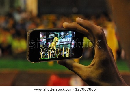 Yangon - Feb 11: A Spectator Uses A Smartphone To Video A Lion Dance On A Downtown Street During Celebrations Ushering In The Chinese New Year Of The Snake On Feb 11, 2013 In Yangon, Burma.