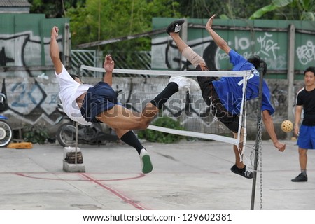 BANGKOK - AUG 20: Takraw players compete in an informal street match on derelict land Aug 20, 2012 in Bangkok, Thailand. Takraw or sometimes Kick Volleyball is one of the national sports of Thailand.