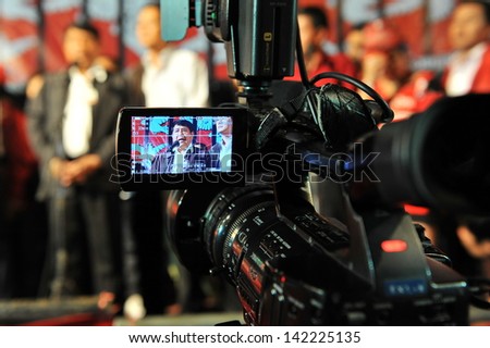 BANGKOK - JAN 29: The Prime Minister\'s deputy secretary-general Tawat Boonfueng seen through the electronic viewfinder of a video camera addresses a large Red Shirt protest on Jan 29, 2013 in Bangkok.