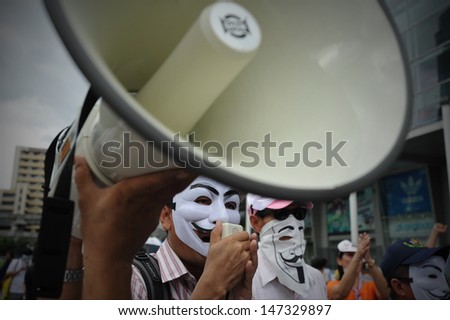 BANGKOK - JULY 21: A masked protester uses a loud hailer to direct an anti-government rally on July 21, 2013 in Bangkok, Thailand. The protesters call for the government to be overthrown.