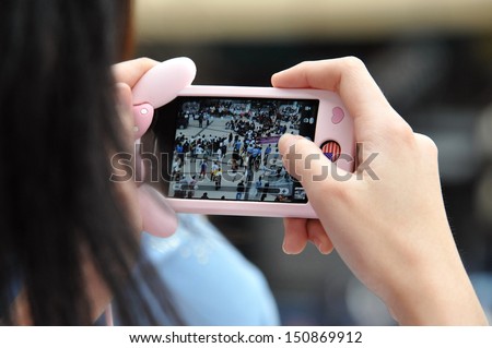 BANGKOK - AUG 17: A protester uses a smartphone to capture an anti-government rally on Aug 17, 2013 in Bangkok, Thailand. Protesters known as V for Thailand protested a controversial amnesty bill.