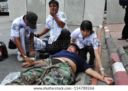 BANGKOK - AUG 7: An injured protester is treated by paramedics after collapsing during an anti-government rally near parliament on Aug 7, 2013 in Bangkok, Thailand.