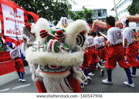 BANGKOK - JUL 21: A lion dance troupe performs on a street on Jul 21 2012 in Bangkok, Thailand. Some Chinese temples in the Thai capital raise funds by sending dance troupes to visit local businesses.