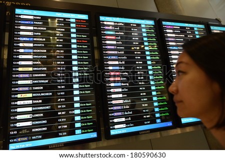 BANGKOK - FEB 20: An unidentified traveller views an arrivals board at Suvarnabhumi International Airport on Feb 20, 2014 in Bangkok, Thailand. The airport handles 45 million passengers annually 2014.