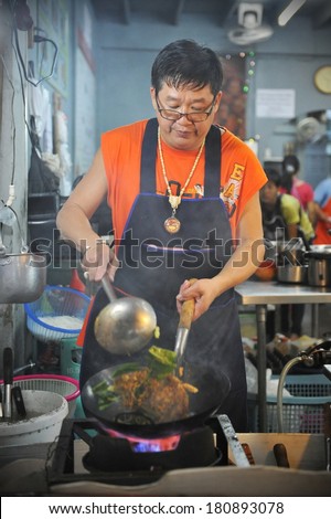 BANGKOK - JAN 27: An unidentified chef cooks food at a street-side restaurant on Jan 27, 2013 in Bangkok, Thailand. There are 16,000 registered street vendors in Bangkok according to government stats.