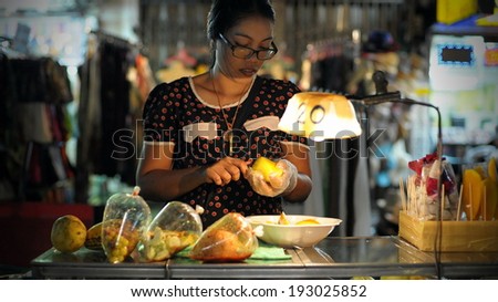BANGKOK - AUG 23: An unidentified street vendor prepares food at a night market on Aug 23, 2012 in Bangkok, Thailand. According gov stats there are over 16,000 registered street vendors in Bangkok.