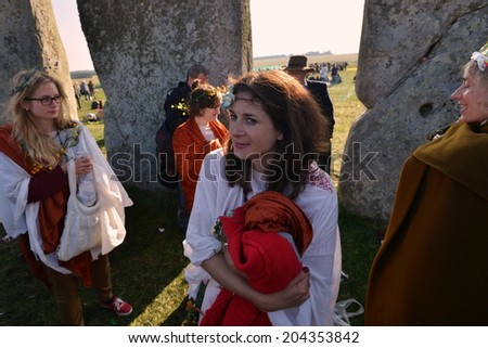 STONEHENGE - JUNE 21: Unidentified revellers join celebrations to mark the Summer Solstice on June 21, 2014 in Stonehenge, UK. Thousands gathered at the historic monument to celebrate the solstice.