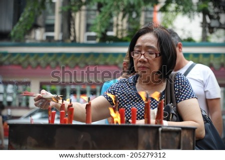 BANGKOK - AUG 2: A woman prays at a temple during a ceremony to mark Buddhist lent on Aug 2, 2012 in Bangkok, Thailand. Buddhist lent or Phansa marks the rainy season when monks retreat to temples.