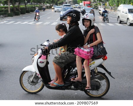 BANGKOK - OCT 17: An unidentified family travel by motorbike during rush hour on Oct 17, 2011 in Bangkok, Thailand. The use of motorbikes as family transport is commonplace in the Thai capital.