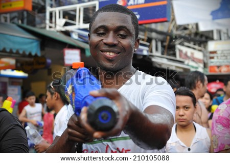 BANGKOK - APRIL 13: An unidentified man poses for a photo at a water fight event on Khao San Road during celebrations of Songkran, or the Thai New Year, on April 13, 2012 in Bangkok, Thailand.