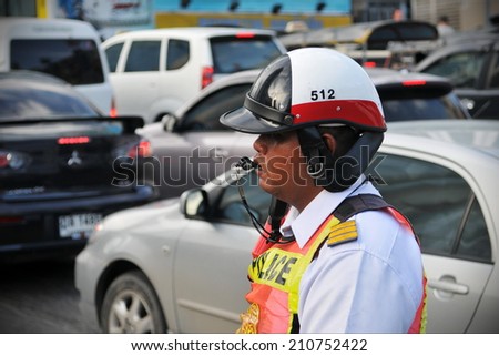 BANGKOK - JUN 15: An unidentified traffic police officer works on a busy road on Jun 15, 2011 in Bangkok, Thailand. Annually an estimated 150,000 new cars join the heavily congested roads of Bangkok.