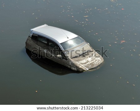 A Car Sits in a Flooded Car Park - Motor Vehicle Insurance Claim Themed Image
