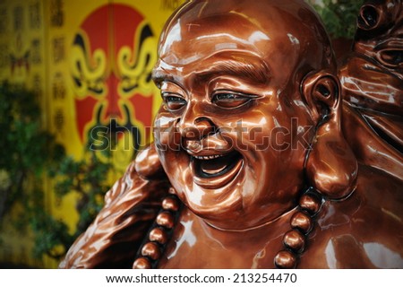 Bronze Coloured Budai Statue at a Taoist Shrine - Budai is Commonly Known as the Laughing Buddha