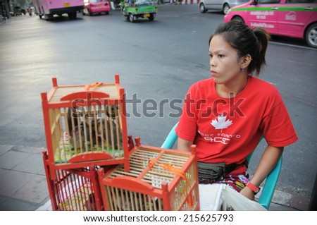BANGKOK - FEB 11: An unidentified woman sells birds at a roadside stall outside the Erawan Shrine on May 24, 2013 in Bangkok, Thailand. Temple-goers believe sending birds free will bring good karma.