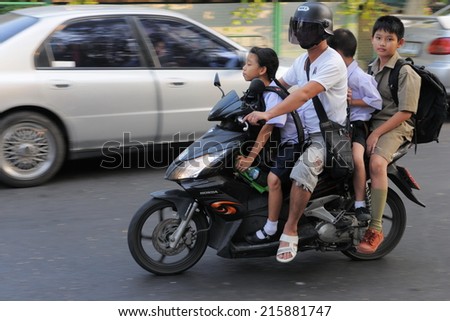 BANGKOK - JAN 20: Unidentified family make a school run by motorbike Jan 20, 2011 in Bangkok, Thailand. The use of motorbikes as family transport is commonplace in Thai capital\'s congested roads.