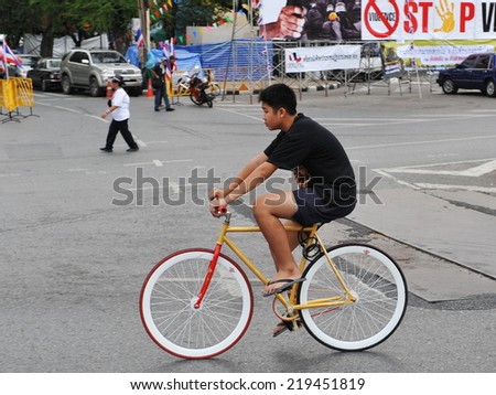 BANGKOK - NOv 22: An unidentified fixed wheel bike cyclist rides along a city street on Nov 22, 2013 in Bangkok, Thailand. Fixie bike riding is a popular activity with youth in the Thai capital.
