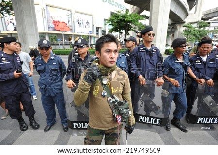 BANGKOK - JUL 21: An unidentified activist stands at a police line during a city centre anti government rally on Jul 21, 2013 in Bangkok, Thailand. Protesters call for the government to be overthrown.