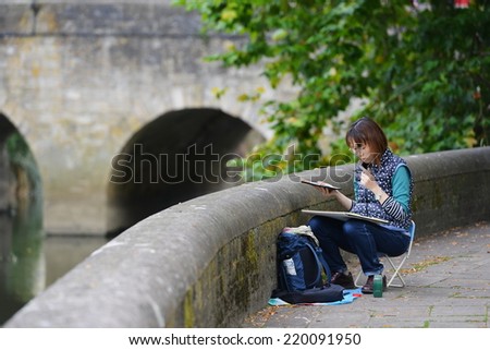 BRADFORD ON AVON - SEP 27: An unidentified Japanese tourist paints town scenery on Sep 27, 2014 in Bradford on Avon, UK. The Wiltshire town is growing in popularity as a travel destination.