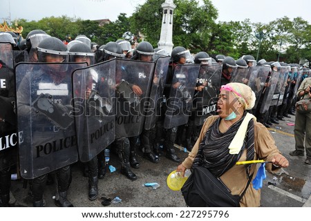 BANGKOK - NOV 24: An anti-government protester confronts riot police during a violent rally on Nov 24, 2012 in Bangkok, Thailand. The protesters call for the government to be overthrown.