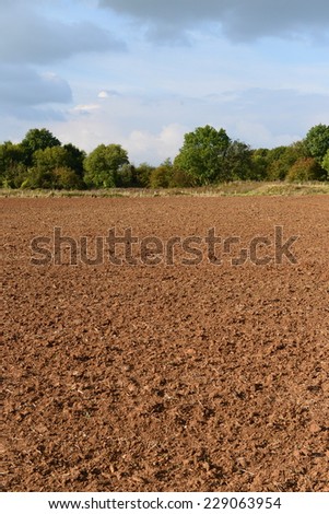 Countryside View of Bare Earth of a Plowed Farmland Field in Rural England