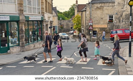 BRADFORD ON AVON - AUG 17: People use a zebra crossing in the town centre on Aug 17, 2014 in Bradford on Avon, UK. Zebra crossings originated in the UK in 1949 and have since been adopted worldwide.