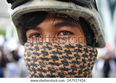 BANGKOK - JUN 2: A masked anti government protesters joins a rally in the Thai capital\'s shopping district on Jun 2, 2013 in Bangkok, Thailand. The protesters call for the government to be overthrown.