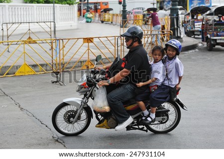 BANGKOK - JUN 5: Unidentified family make a school run by motorbike during evening rush hour on Jun 5, 2011 in Bangkok, Thailand. The use of motorbikes as family transport is commonplace in Thailand.