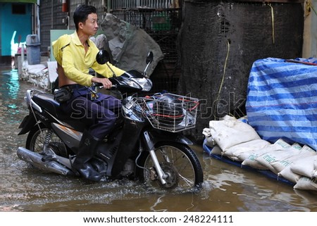 BANGKOK - OCT 26: A motorbike rider navigates a flooded street in Chinatown after the heaviest monsoon rains in over 50 years on Oct 26, 2011 Bangkok, Thailand.