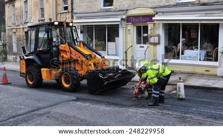 BRADFORD ON AVON - JUL 13: Labourers carry out road work repairs on Jul 13, 2010 in Bradford on Avon, UK. In the UK vehicle tax contributes towards repairs and improvements to roads.