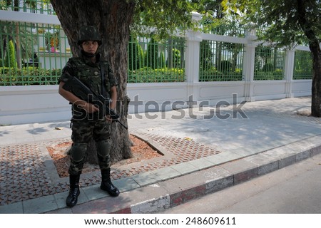 BANGKOK - FEB 11: An armed Thai soldiers stands guard on a street near government buildings as anti election Yellow Shirt protesters hold a rally in the vicinity on Feb 11, 2011 in Bangkok, Thailand.