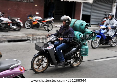 BANGKOK - DEC 17: A motorbike courier carries gas canisters on a city street on Dec 17, 2010 in Bangkok, Thailand. Traffic laws and safety regulations are often unenforced and ignored in Thailand.