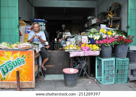 BANGKOK - DEC 17: A man works in florist shop on a city street on Dec 17, 2010 in Bangkok, Thailand. The Thai capital is a main driver of the economy with a GDP worth 29% of the country\'s output.