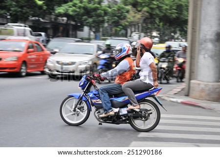 BANGKOK - DEC 17: A motorbike taxi transports a passenger on a city street on Dec 17, 2010 in Bangkok, Thailand. Motorbike taxis are a popular choice for the Thai capital\'s heavily congested roads.