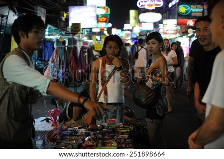 BANGKOK - JAN 4: Tourists watch a magic show on Khao San Road on Jan 4, 2011 in Bangkok, Thailand. Khao San is popular with backpackers for its nightlife and affordable accommodation.