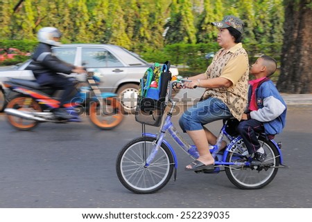 BANGKOK - JAN 20: A family make a school run by bicycle on Jan 20, 2011 in Bangkok, Thailand. The government plans to build cycle lands and encourage the use of bicycles to combat road congestion.