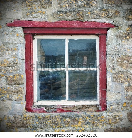 Wooden Framed Square Window and Stone Wall of an Old Cottage House