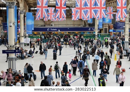 LONDON - MAY 30: Travellers walk through Victoria train station on May 30, 2015 in London, UK. Victoria is the second busiest train station in the UK with 73 million passengers entry and exits.