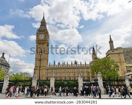 LONDON - MAY 30: Tourists walk past Big Ben and Houses of Parliament on a beautiful sunny day on May 30, 2015 in London, UK. London had 16.8 million international visitors in 2013.