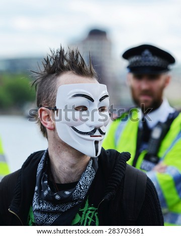 LONDON - MAY 30: A protester wears a V for Vendetta mask during a rally against public sector spending cuts following the re-election of the Conservative party on May 30, 2015 in London, UK.