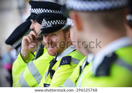 LONDON - MAY 30: Police stand guard during a rally against government public sector spending cuts following the re-election of the conservative party on May 30, 2015 in London, UK.