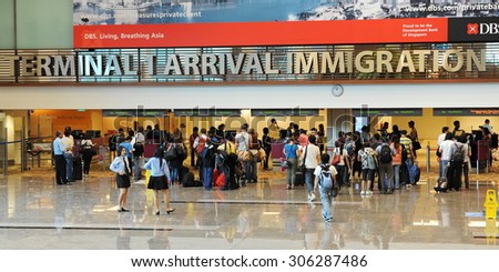 SINGAPORE - NOV 12: Travelers enter immigration control at Changi International Airport on Nov 12, 2011 in Singapore. Changi is a main aviation hub in SE Asia, handling 66 million passengers per year.